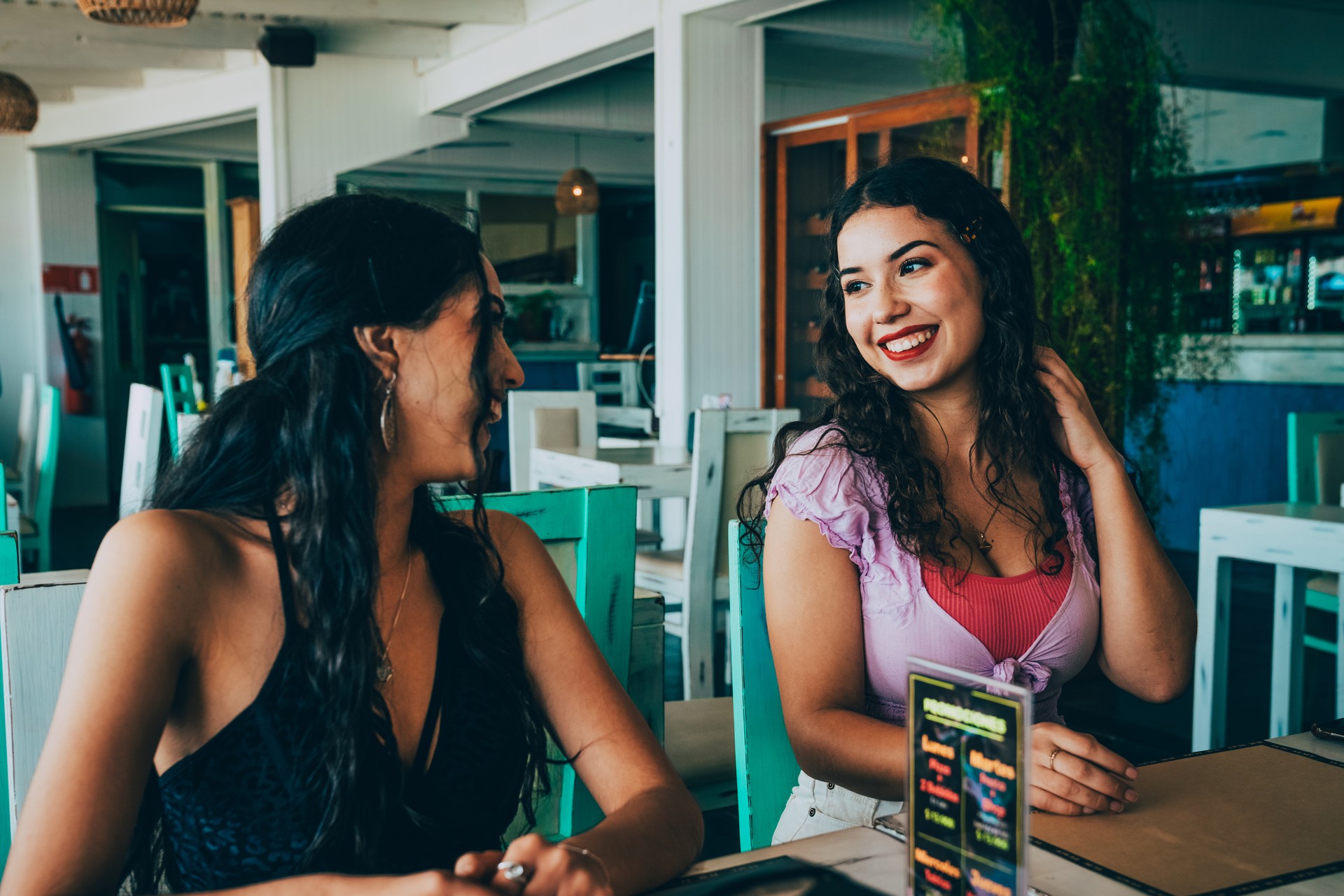 Female friends smiling while enjoying time together in a restaurant.